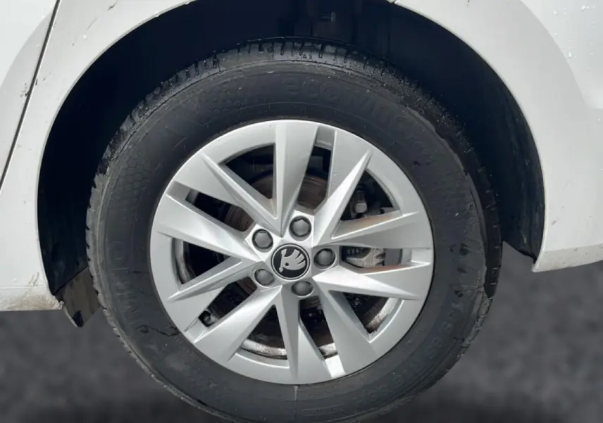Gros plan sur la roue avant droite blanche d'une Skoda Fabia 2025 avec jante alu à 10 branches.