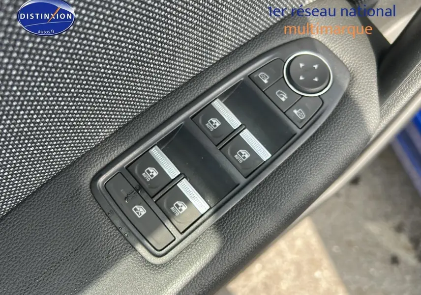Gros plan sur les commandes de lève-vitres et rétroviseurs sur la porte côté conducteur d’un Renault Captur Bleu Iron.