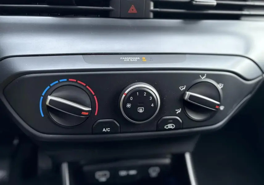 Gros plan sur les commandes de climatisation manuelle de la Hyundai i20 2025, avec réglages température, ventilation et air recyclé.