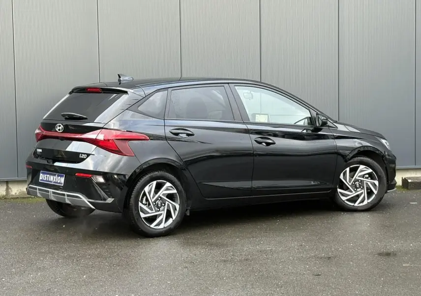 Vue 3/4 arrière droite d'une Hyundai i20 noire Phantom Metal avec jantes alliage diamantées et vitres surteintées.