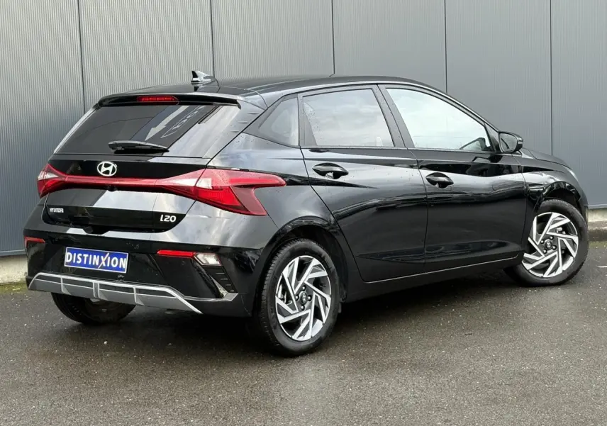 Vue 3/4 arrière droite d'une Hyundai i20 2025 noir Phantom Metal avec jantes alliage diamantées et feux LED distinctifs.