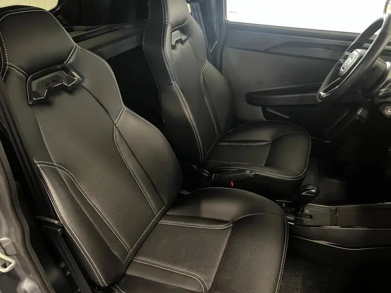 Vue intérieure côté droit montrant les sièges sport noirs avec surpiqûres blanches du Ligier JS50 Sport Elite E5+ gris 2025.