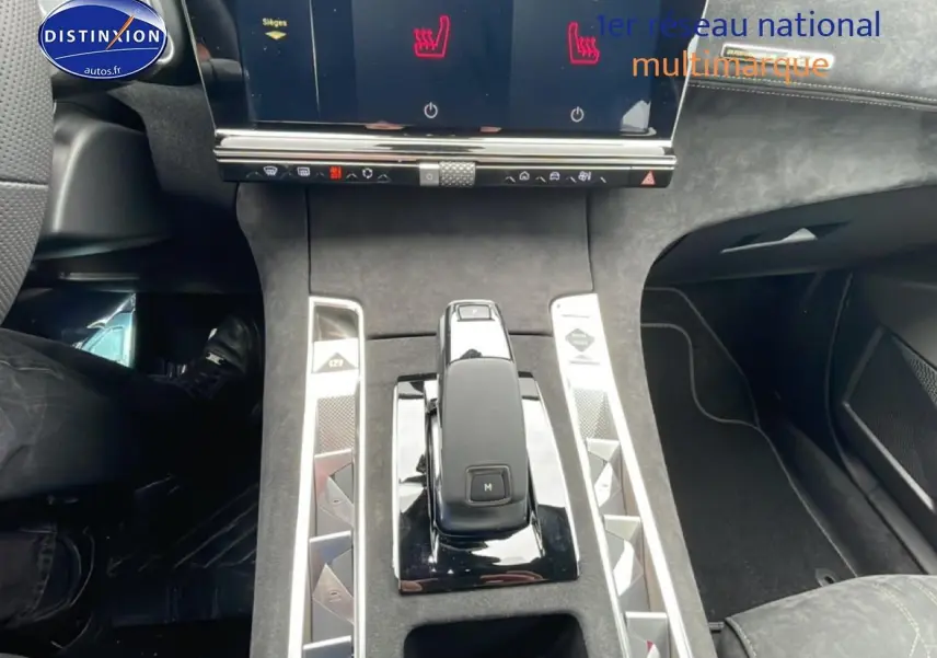 Vue intérieure centrée sur la console centrale du DS7 gris titane, mettant en valeur le levier de vitesses et l'écran tactile.