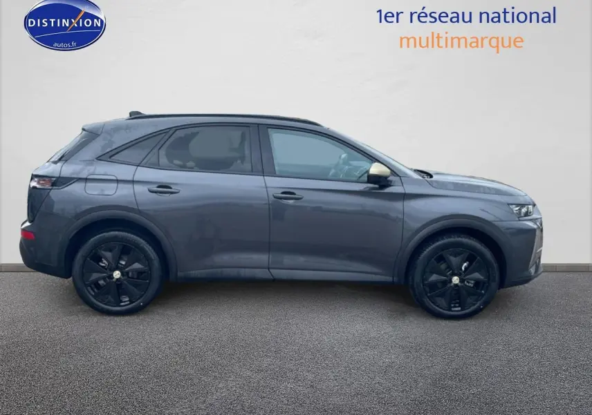 Vue de profil côté gauche d'un DS7 gris titane avec jantes noires et rétroviseurs couleur carrosserie.