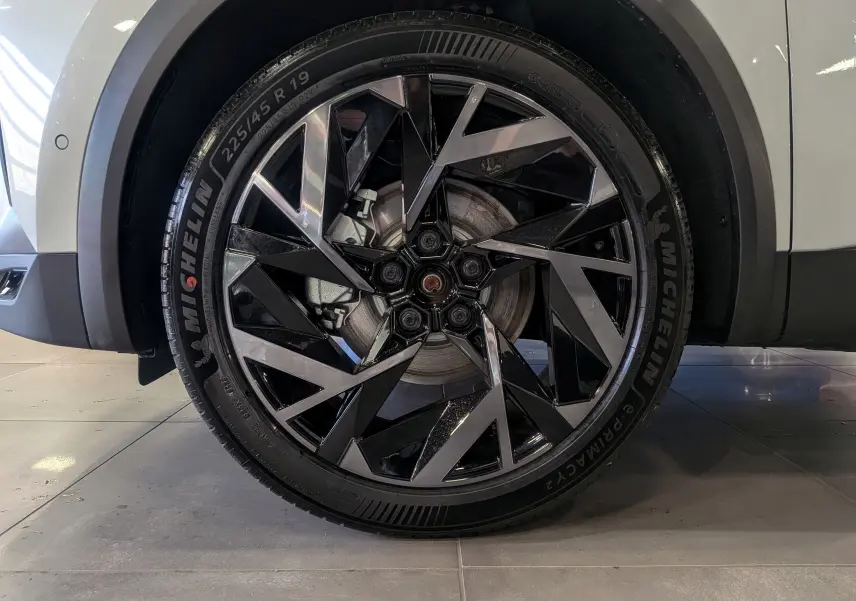 Gros plan sur la roue avant droite du Renault SYMBIOZ blanc nacré, avec jante noire et argentée au design géométrique.