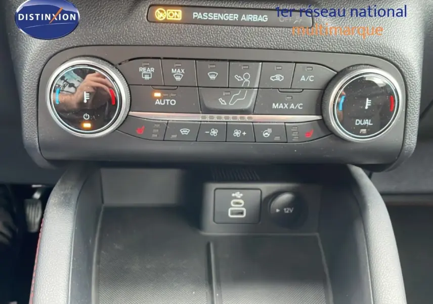 Vue rapprochée du tableau de bord du Ford Kuga 2024, montrant la climatisation automatique et les commandes USB et 12V.