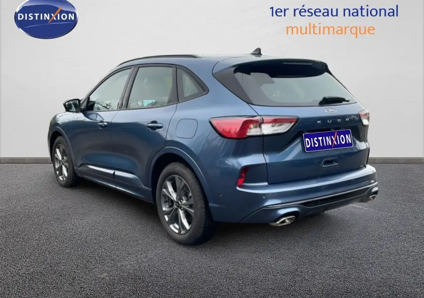 Vue 3/4 arrière droite d’un Ford Kuga 2024 bleu Vapor Metal avec jantes alliage et double sortie d’échappement.