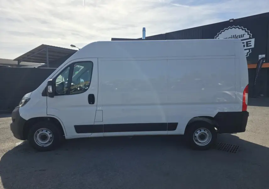 Vue de profil côté gauche d’un fourgon FIAT Ducato blanc 2023 avec porte latérale coulissante et jantes acier.