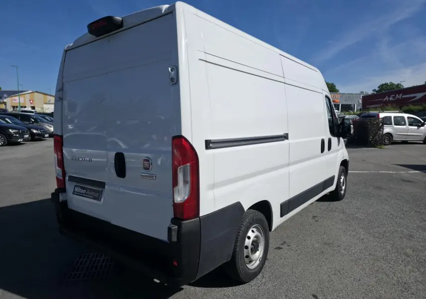 Vue 3/4 arrière droite d'un FIAT Ducato Fourgon blanc 2023 avec portes arrière tôlées et jantes acier 15 pouces.