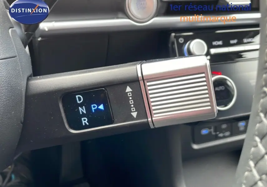 Gros plan sur le levier de vitesses automatique du Hyundai Tucson blanc Atlas, avec affichage digital des modes de conduite.