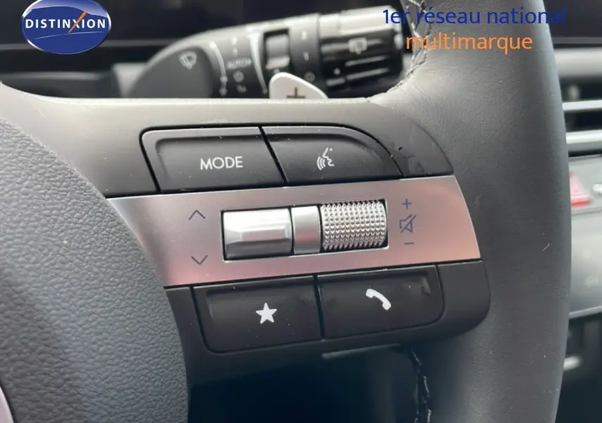 Gros plan sur les commandes multifonctions à gauche du volant cuir noir du Hyundai Tucson blanc Atlas 2026.