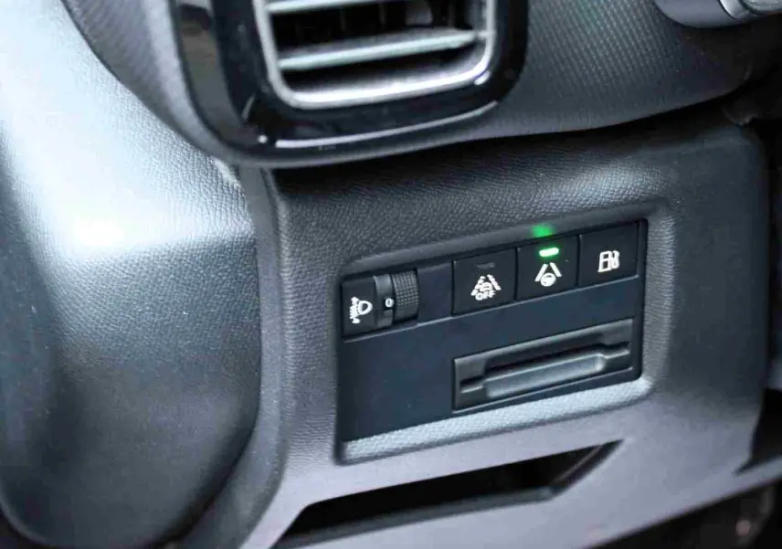 Détail intérieur côté gauche montrant les commandes d'assistance et réglage des phares du Citroën C5 Aircross gris platinium hybride rechargeable.