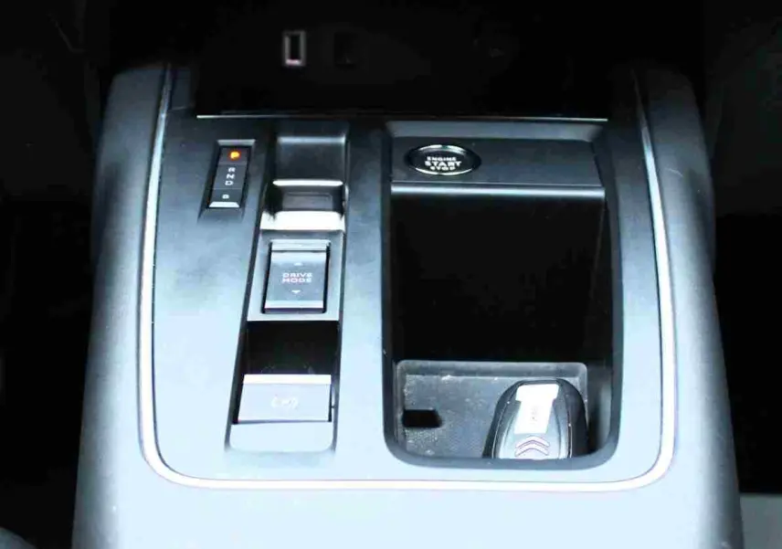 Gros plan sur la console centrale noire du Citroën C5 Aircross hybride, avec bouton start et commandes de boîte automatique.
