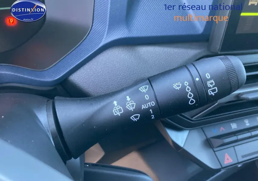 Gros plan sur la commande des essuie-glaces du tableau de bord intérieur du Dacia Duster 2025, détails des symboles blancs.