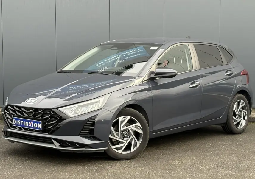 Vue 3/4 avant droite de la Hyundai i20 2025 gris Aurora Metal avec jantes alliage diamantées et calandre noire.