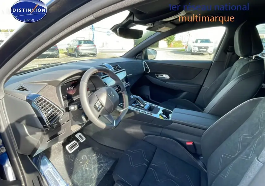 Vue intérieure côté conducteur du DS7 bleu 2026, mettant en valeur le volant cuir, la console centrale et les sièges noirs.