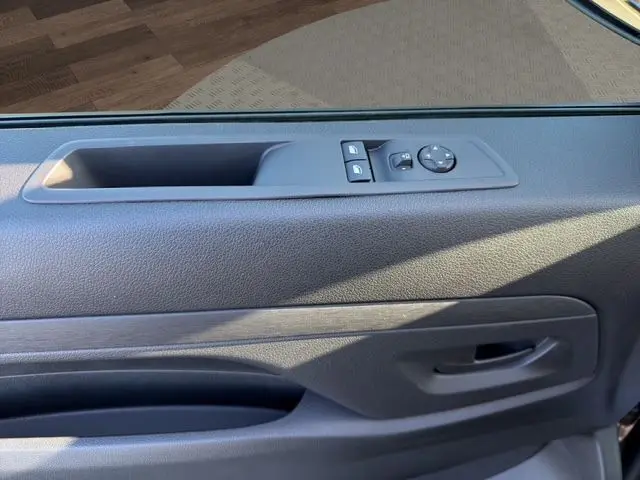 Gros plan sur la porte intérieure côté gauche du Citroën Jumpy gris titane, avec commandes électriques des vitres et rétroviseurs.