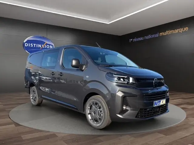 Vue 3/4 avant droite du Citroën Jumpy gris titane avec projecteurs LED et porte latérale droite visible en showroom.