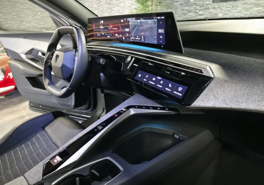 Vue intérieure côté conducteur du Peugeot 5008 2025 noir, avec tableau de bord numérique panoramique et console centrale moderne.