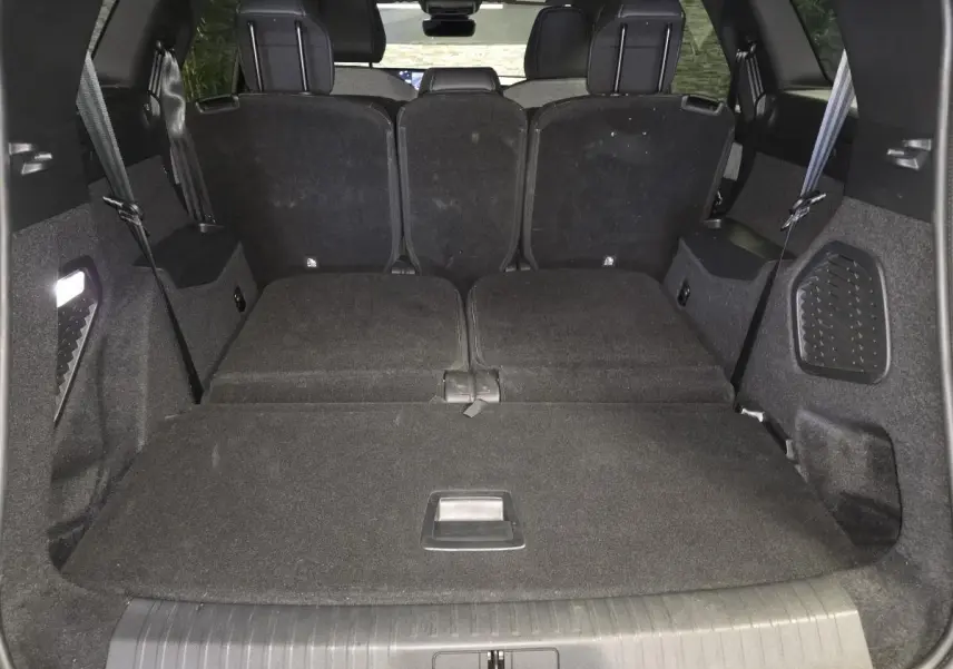 Vue du coffre arrière du Peugeot 5008 noir 2025 avec banquette arrière partiellement rabattue et espace de chargement plat.