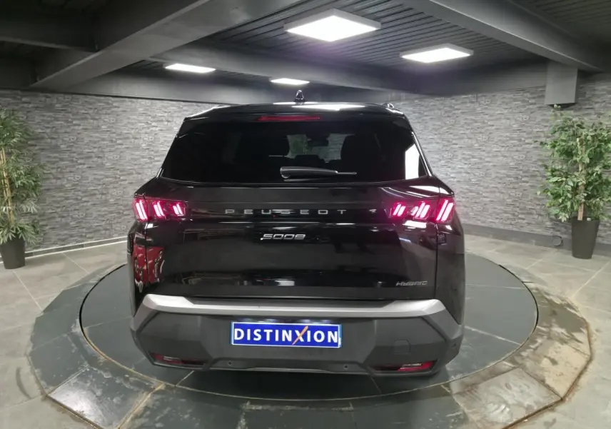 Vue arrière du Peugeot 5008 hybride noir 2025 avec feux arrière LED 3 griffes et bandeau noir laqué.