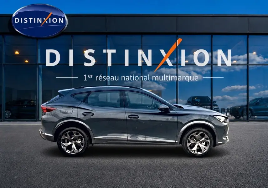 Vue latérale droite d'un CUPRA Formentor bleu fjord 2026 garé devant une vitrine avec logo Distinxion.