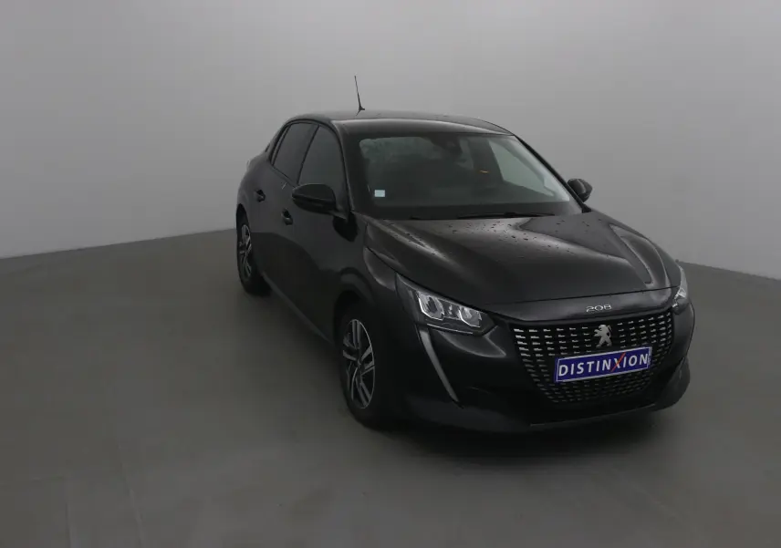 Peugeot 208 noire vue en 3/4 avant droit avec calandre distinctive et phares LED allumés.