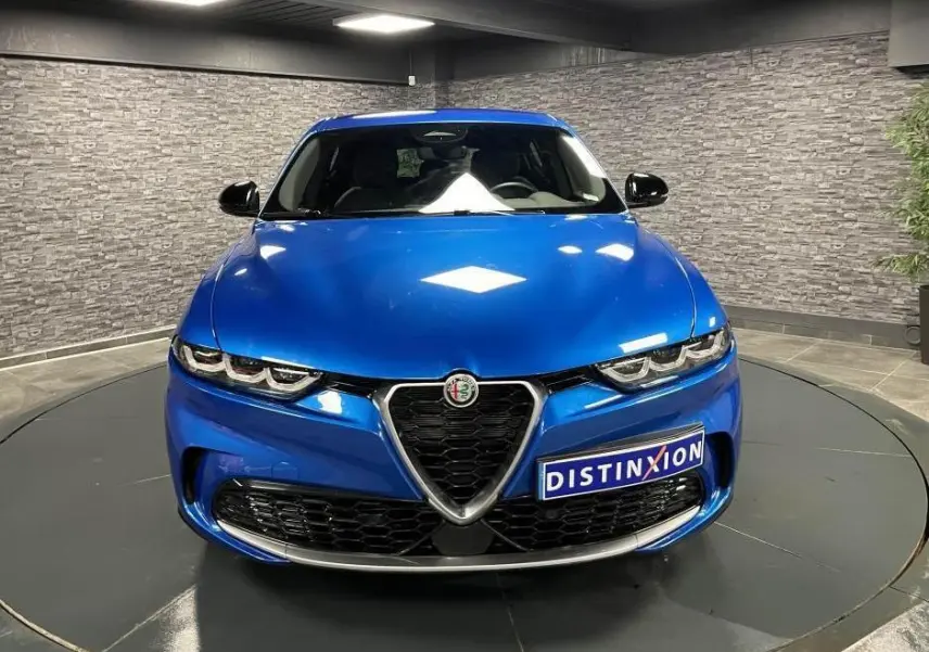 Vue frontale d'une Alfa Romeo Tonale 1.5 mHEV 160 TI bleu métallisé avec calandre caractéristique et rétroviseurs noirs.