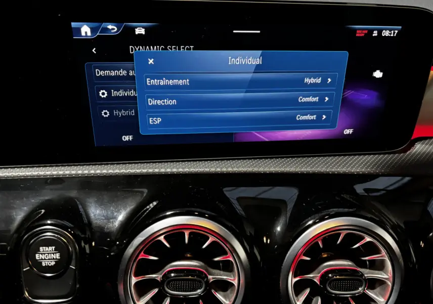 Vue rapprochée du tableau de bord noir de la Mercedes CLA 250 e AMG Line 2023, écran tactile et commandes circulaires d’aération.