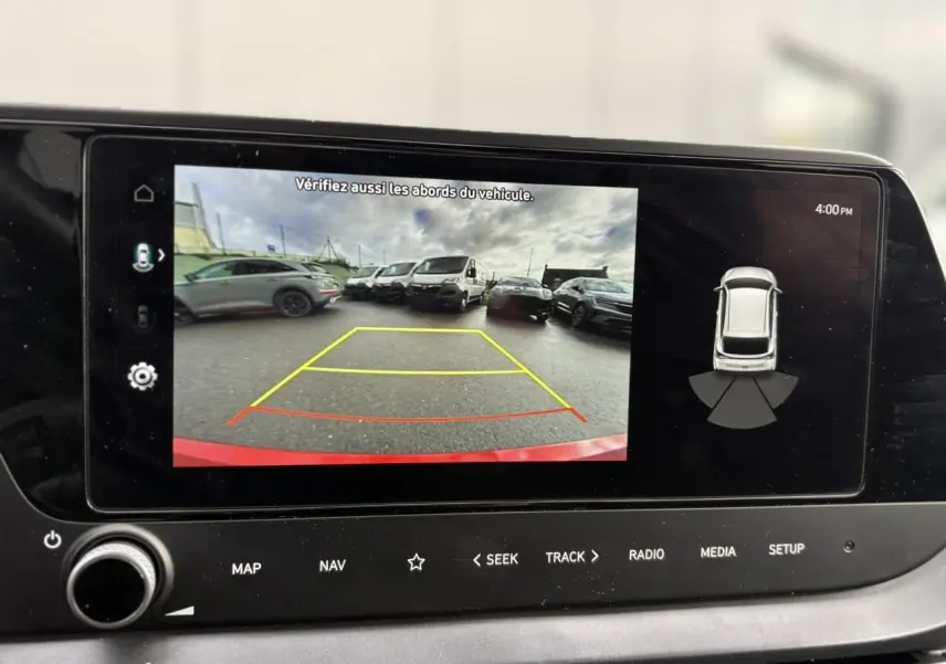 Écran tactile de la Hyundai i20 2025 montrant la caméra de recul avec vue arrière et alertes de proximité.