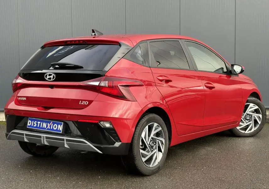 Vue 3/4 arrière droite d'une Hyundai i20 rouge Dragon Metal avec jantes alliage et vitres teintées.