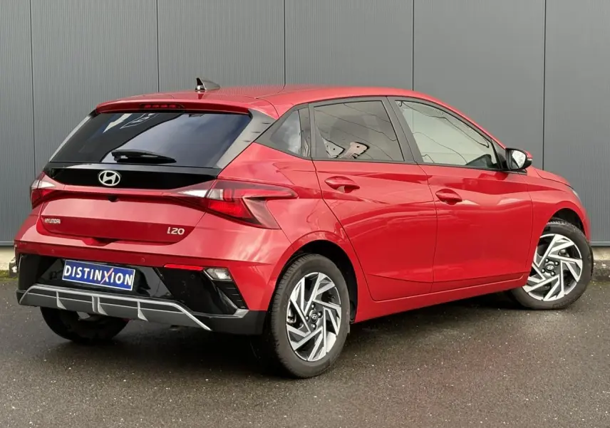 Vue 3/4 arrière droite d'une Hyundai i20 rouge Dragon Metal avec jantes alliage 16'' diamantées et vitres surteintées.