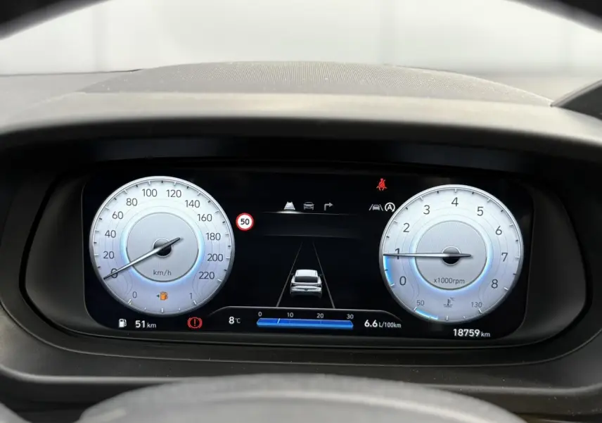 Vue rapprochée du tableau de bord numérique de la Hyundai i20 2025, affichant vitesse, régime et alertes.