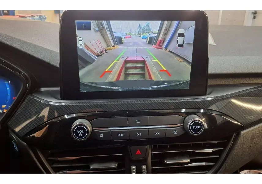 Vue intérieure du tableau de bord du Ford Kuga 2024 avec écran tactile affichant la caméra de recul en marche.