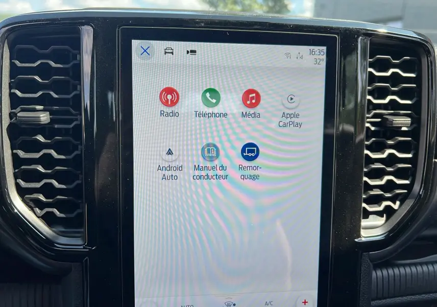 Écran tactile central du Ford Ranger 2025 affichant les options Radio, Téléphone, Média et Apple CarPlay, entouré de grilles d’aération noires.