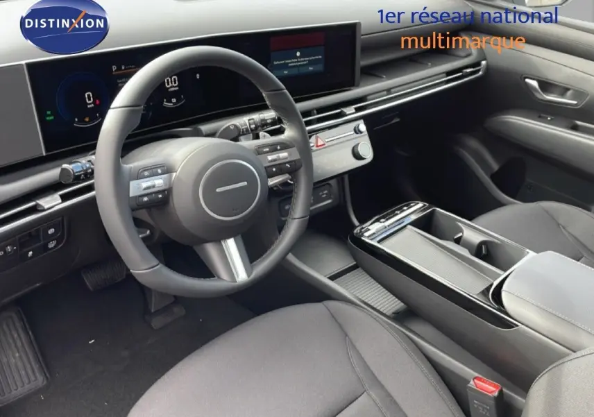 Vue intérieure côté conducteur du Hyundai Tucson 2026, tableau de bord moderne avec écran digital et sellerie tissu noir.