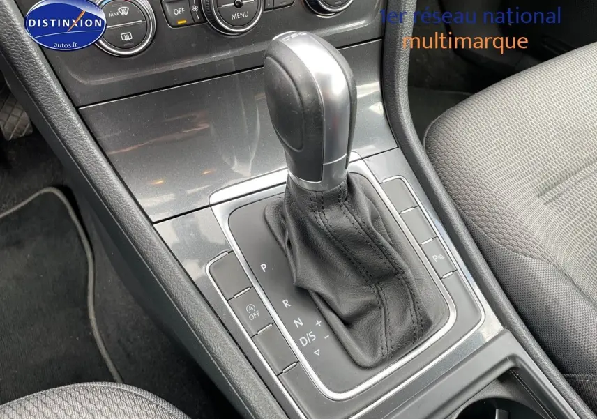 Gros plan sur la console centrale de la Volkswagen Golf VII rouge, mettant en valeur le levier de vitesses automatique en cuir noir.