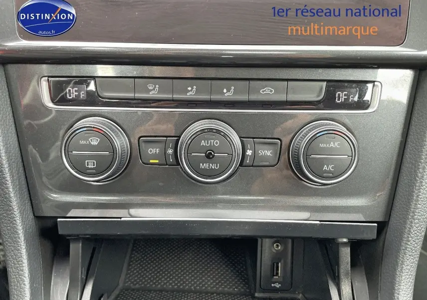 Détail de la console centrale de la Volkswagen Golf VII rouge, montrant les commandes de climatisation et ventilation.