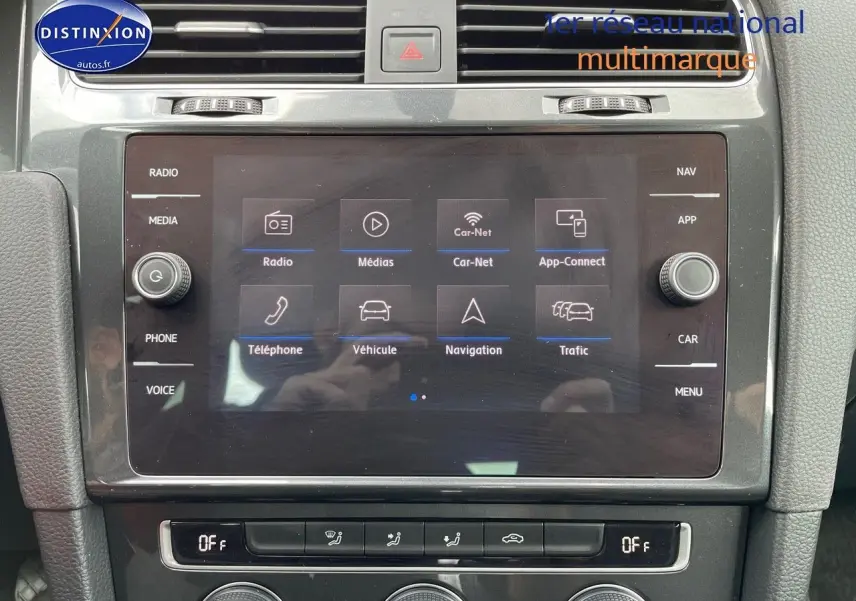Écran tactile central en gros plan dans l’habitacle d’une Volkswagen Golf VII rouge, affichant le menu multimédia.