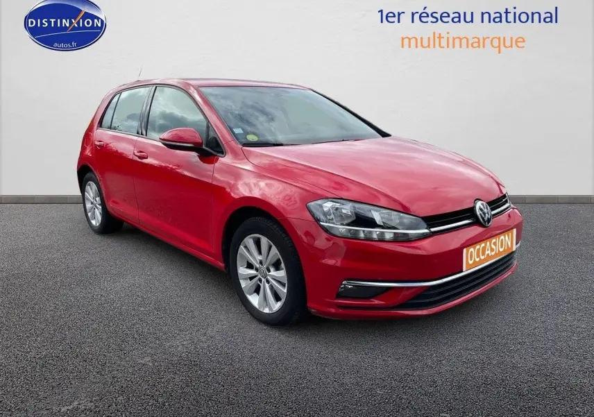 Volkswagen Golf VII rouge vue 3/4 avant droit sur sol gris avec plaque "OCCASION" orange.
