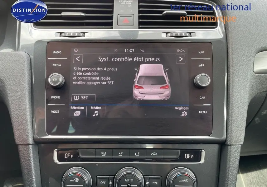 Vue rapprochée de l’écran central tactile de la Volkswagen Golf rouge, affichant le contrôle de pression des pneus.