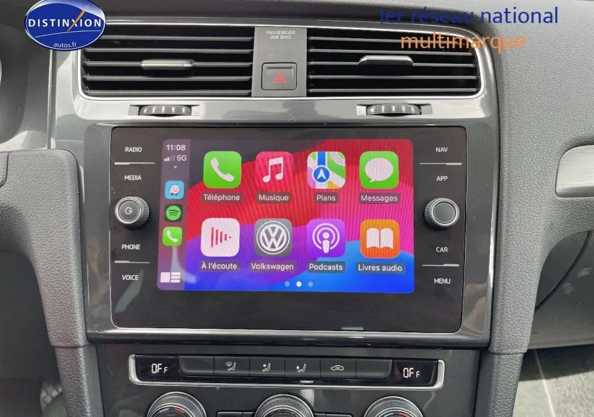 Vue rapprochée de l’écran tactile central du tableau de bord d’une Volkswagen Golf rouge de 2018, affichant l’interface multimédia.