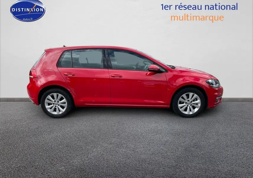 Profil droit d'une Volkswagen Golf VII rouge de 2018, avec jantes alliage et vitres légèrement teintées.