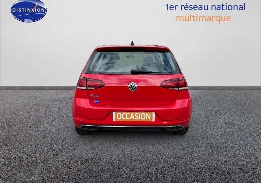 Vue arrière d'une Volkswagen Golf rouge 2018 avec logo et plaque "OCCASION" visible sur un sol gris.