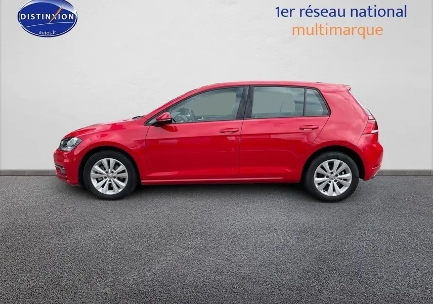 Profil droit d'une Volkswagen Golf VII rouge de 2018, avec jantes alliage et vitres teintées, sur fond neutre.