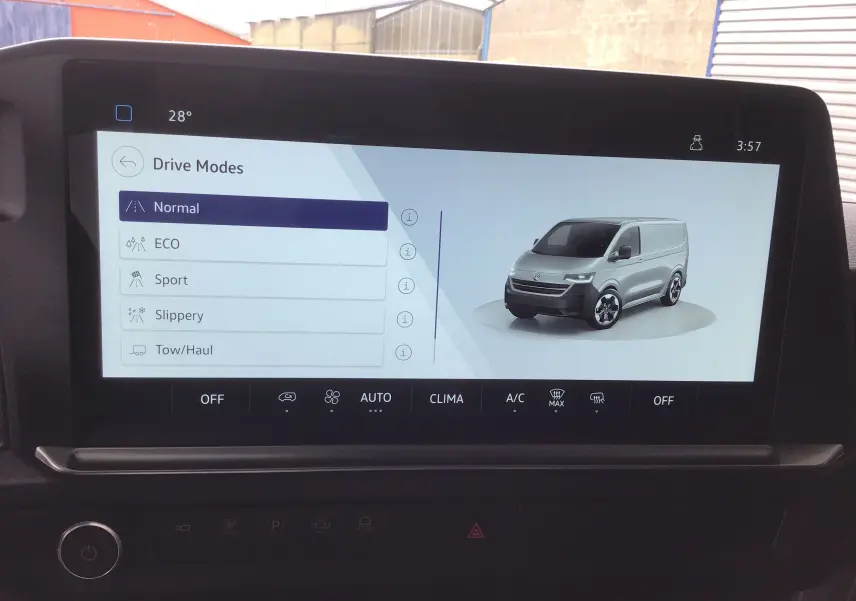 Écran tactile intérieur montrant les modes de conduite avec illustration du Volkswagen Transporter T7 gris anthracite en vue 3/4 avant.