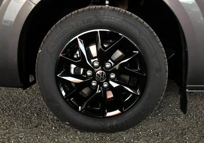 Gros plan sur la roue avant droite du Volkswagen Transporter T7 gris anthracite avec jante noire brillante et pneu Goodyear.