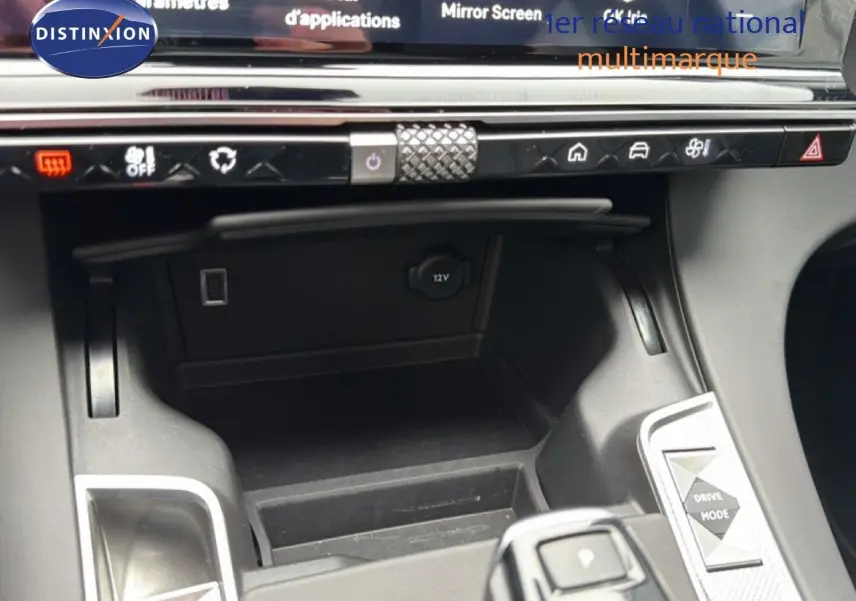 Vue rapprochée de la console centrale du DS7 2024 gris titane, montrant les commandes de climatisation et prise 12V.