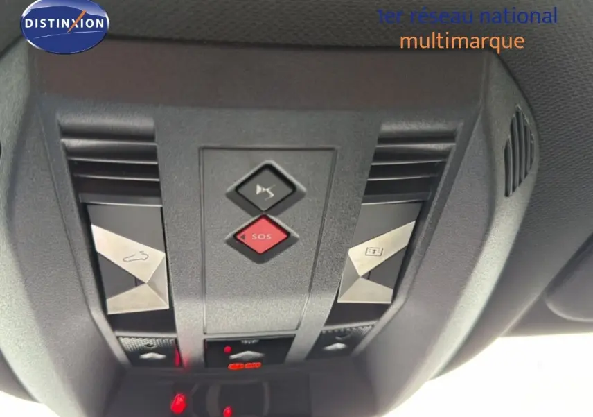 Vue en gros plan du panneau de commandes au plafond du DS7 gris titane, avec bouton SOS rouge et commandes d'ouverture toit ouvrant.
