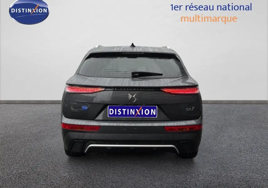 Vue arrière d'un DS7 gris titane métal 2024 avec feux LED étirés et logo DS centré sur le hayon.